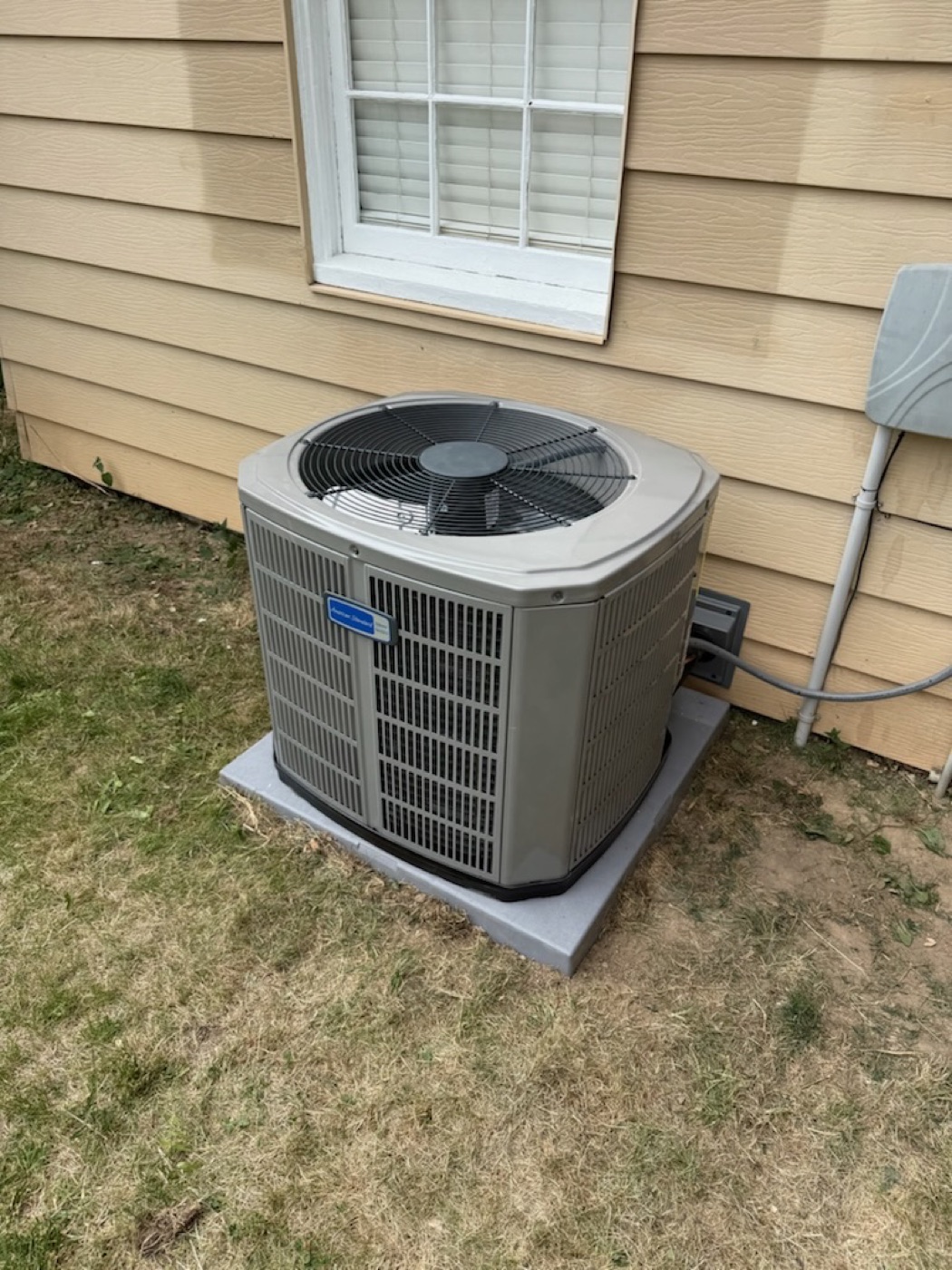 New AC condenser installed beside a home by Cowboy Heating & Cooling