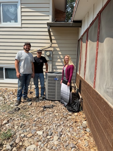 The Cowboy Heating & Cooling crew with the winner of the free AC giveaway beside their brand-new American Standard system
